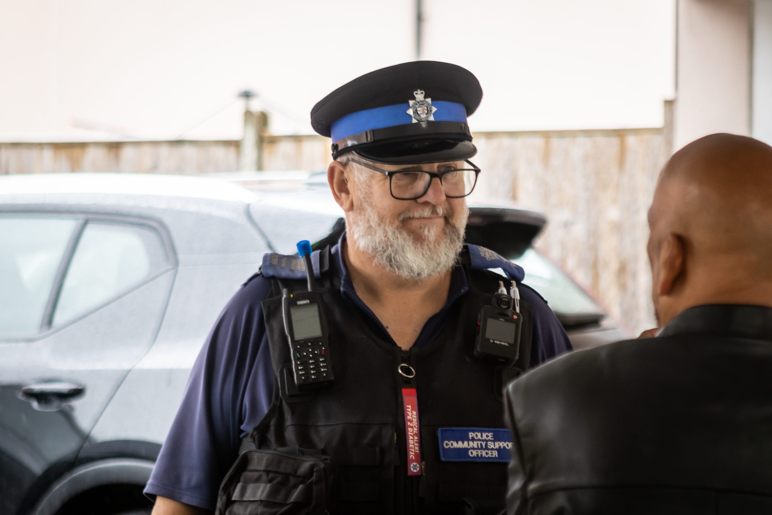 A police community support officer talks to a colleague on a stonewater scheme.