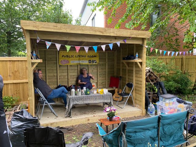 People sitting in an outdoor public living room at Westcott Community Garden, Swindon